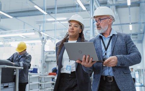 Two occupational safety professionals holding a laptop.