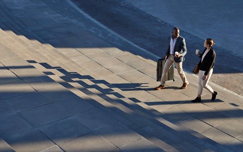Two business professionals walking outdoors.