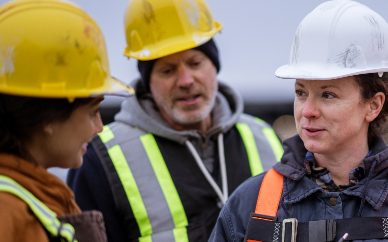 Workers wearing safety helmets and high-visibility vests.